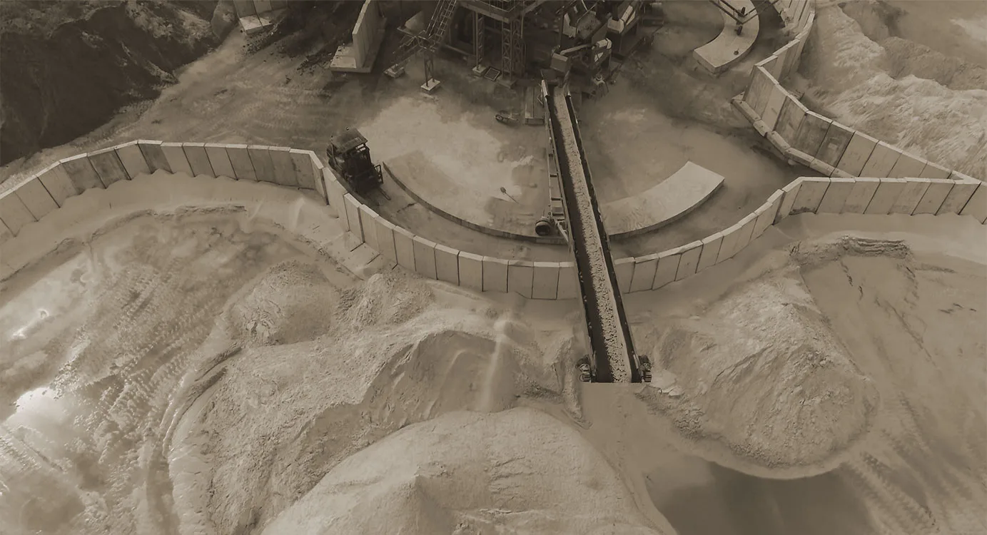 Looking down into a thickener tank with its rake arm over settled sand