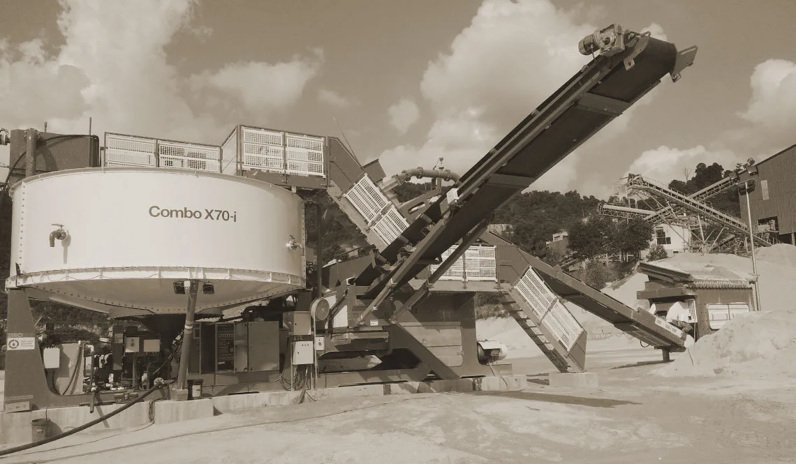 A CFlo Combo X70-i with its conveyors raised, seen against a cloudy sky