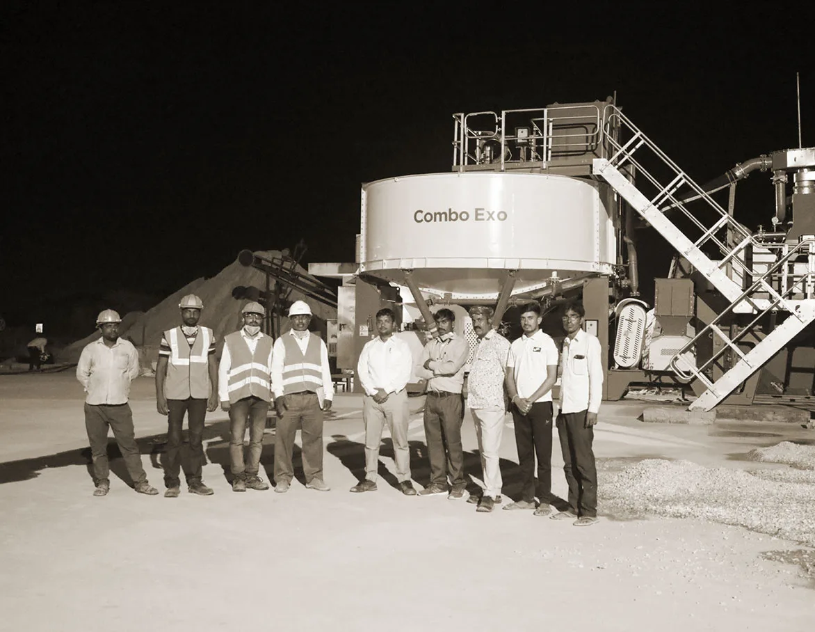 A site team in hard hats and hi-vis lined up in front of a CFlo Micrograder Exo plant