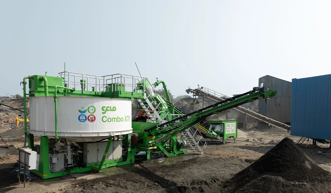 A green CFlo Combo X70 unit with walkways, beside a dark stockpile