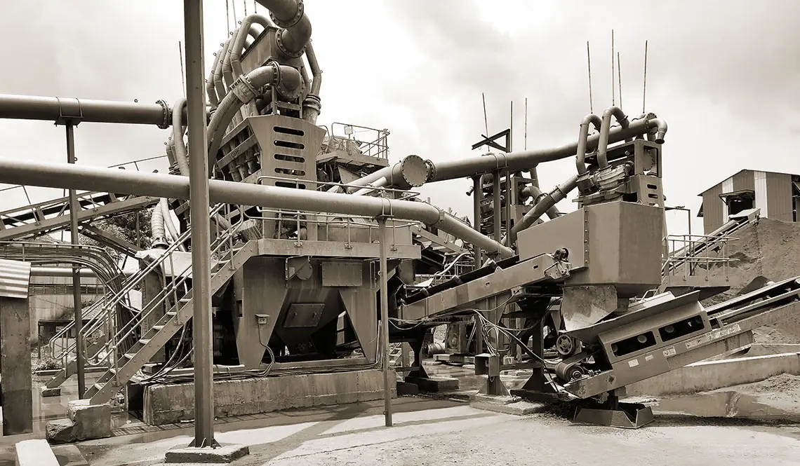 The Pacific Industries iron ore fines plant, a tall bank of hydrocyclones and pipework above the classification modules with product conveyors running out to the stockpiles